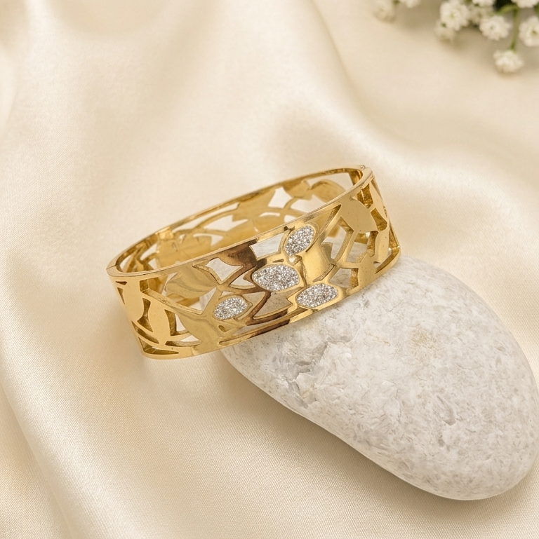 Gold bangle kada with a floral pattern and small clear stones