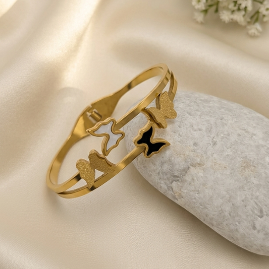gold-toned open cuff bracelet with butterfly-shaped 