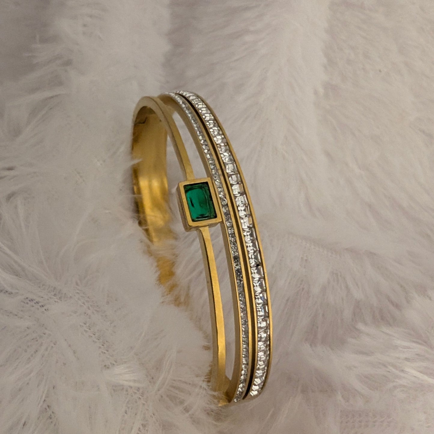 Gold bracelet with a green gemstone