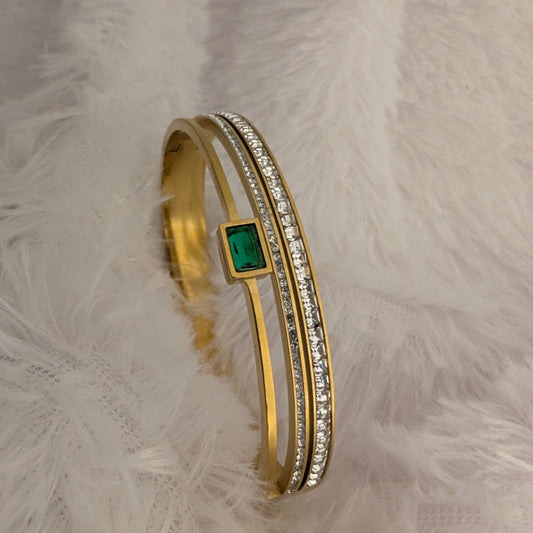 Gold bracelet with a green gemstone