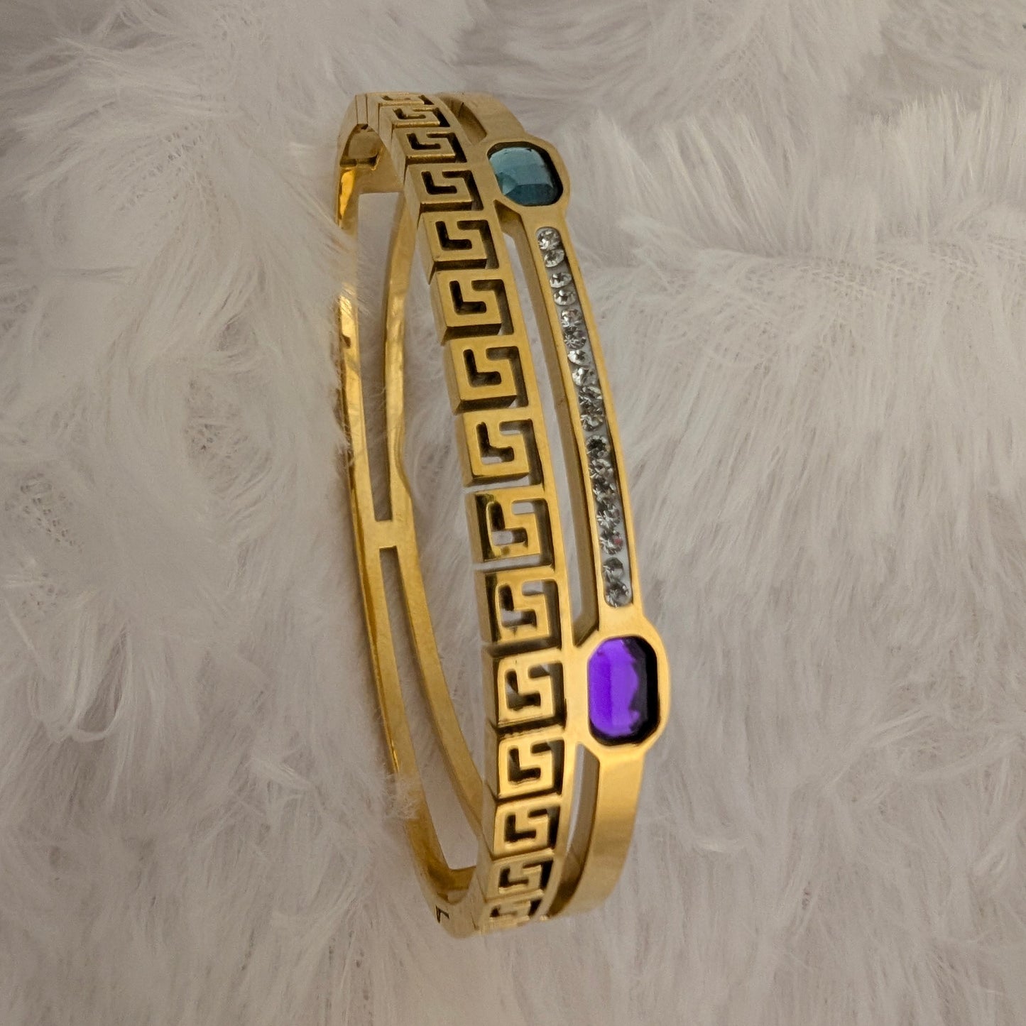 gold bracelet with blue and sea green emerald and white stones studded
