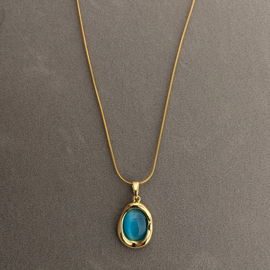 Gold necklace with a blue pendant