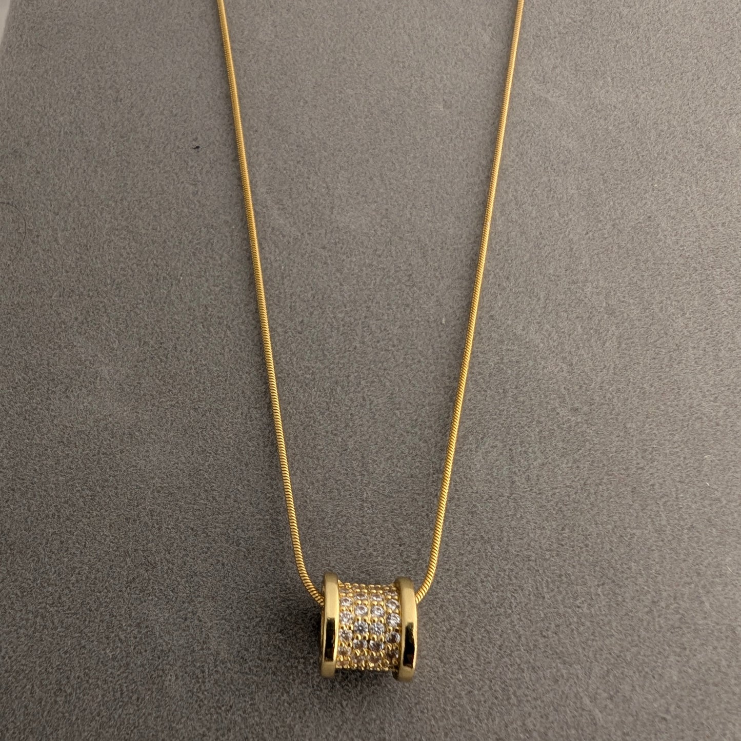 Gold necklace with a cylindrical pendant