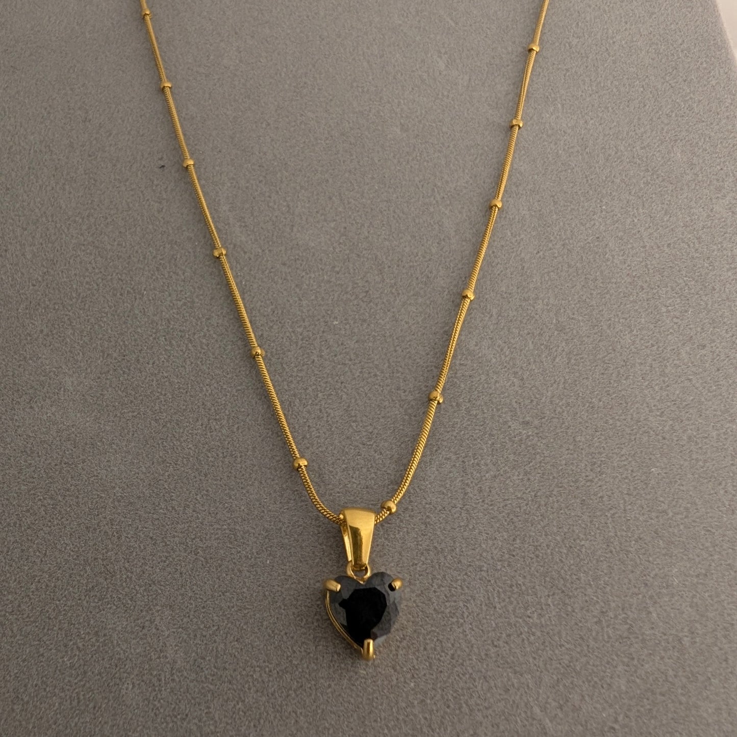 Gold necklace with a heart-shaped black gemstone