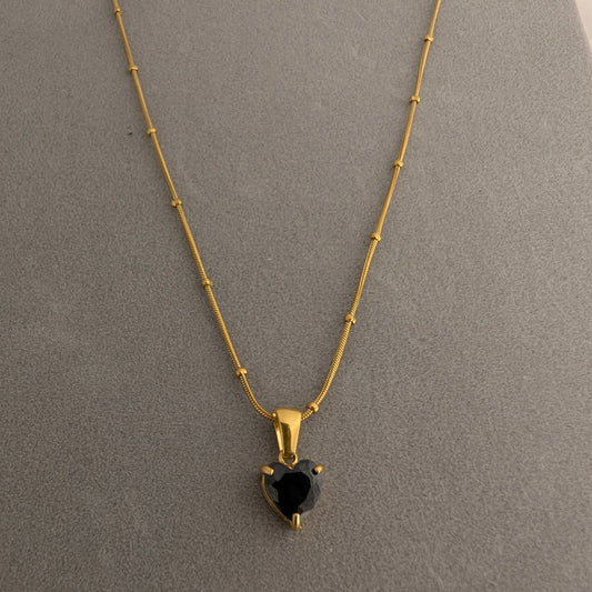Gold necklace with a heart-shaped black gemstone