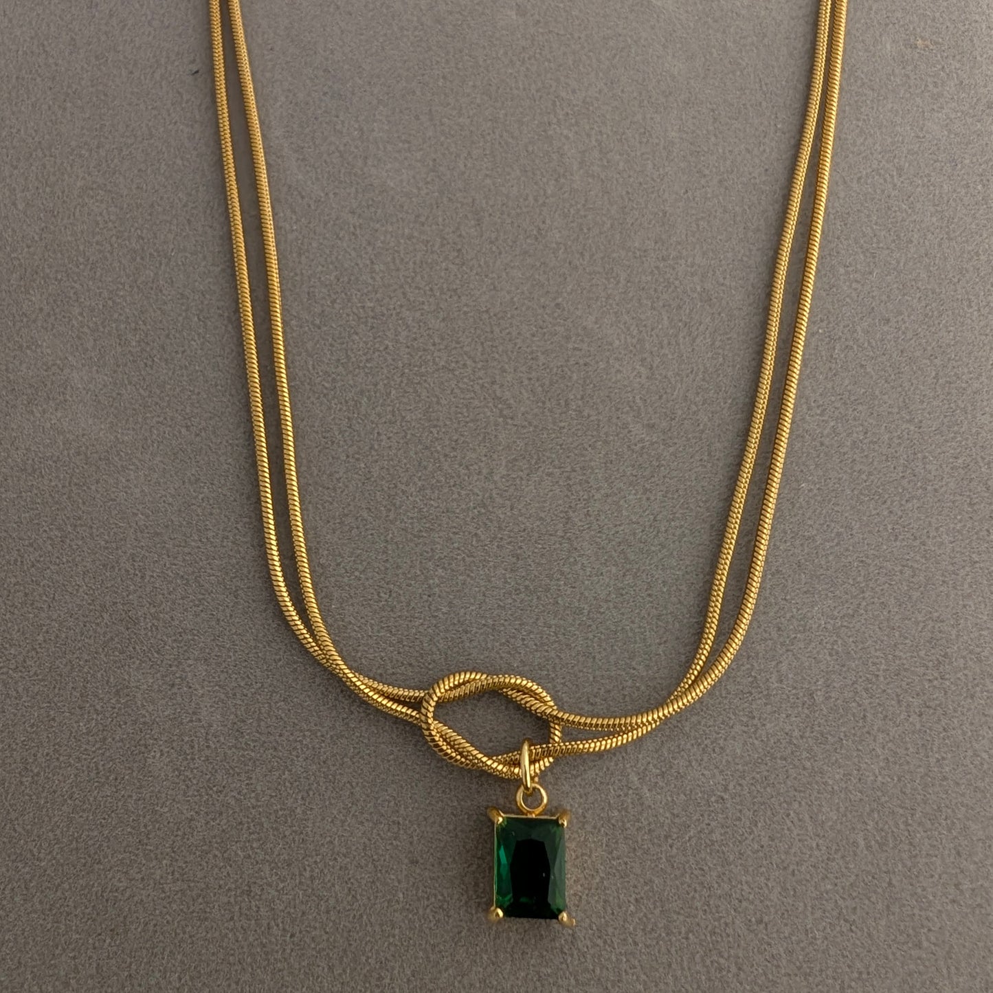 Gold necklace with a green gemstone pendant